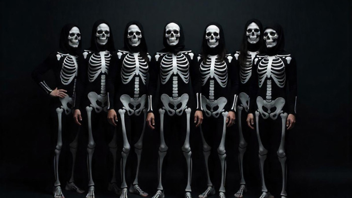 An image of the skeleton photoshoot idea for Halloween, featuring a group of people dressed in skeleton bodysuits. 