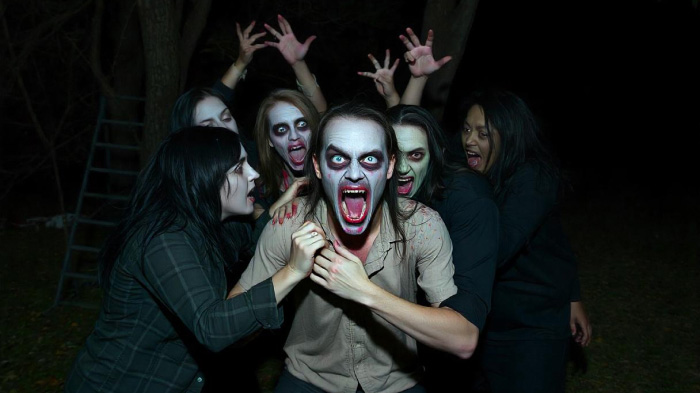 An image of the zombie group photoshoot idea for Halloween, featuring people as zombies in an attacking pose.