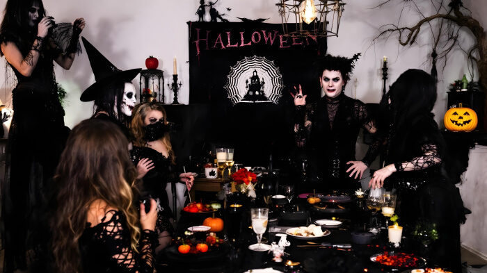 An image featuring a Gothic masquerade ball Halloween party idea with a dark-themed decor and outfits.