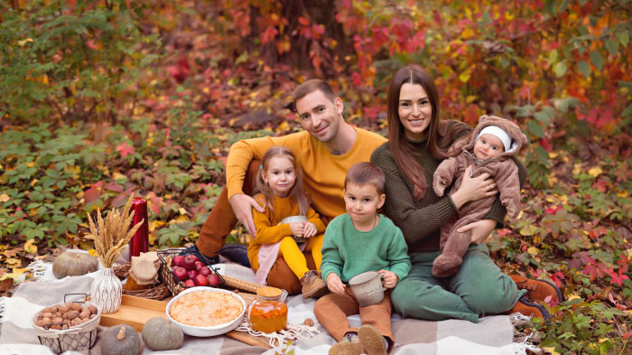 A Thanksgiving photo of a family enjoying a picnic in the backyard of the house. 