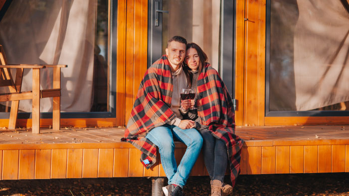 A Thanksgiving photo of a couple on the porch, featuring cozy vibes.