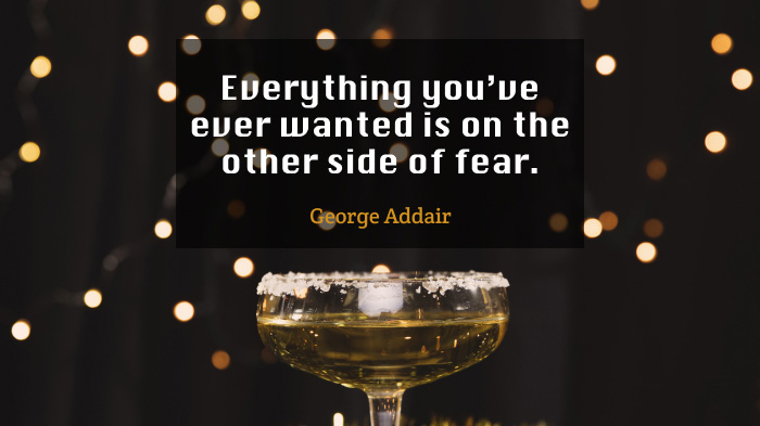 An image with a black background with bokeh effect and an inspirational quote by George Addair