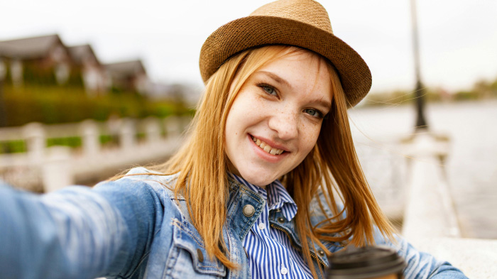 A vibrant outdoor selfie of a woman with good lighting and colors.